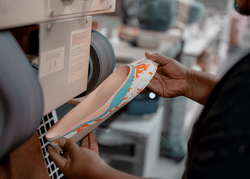 A person customizing a shoe insert for men and women with foot conditions to wear walking or running orthotic shoes.